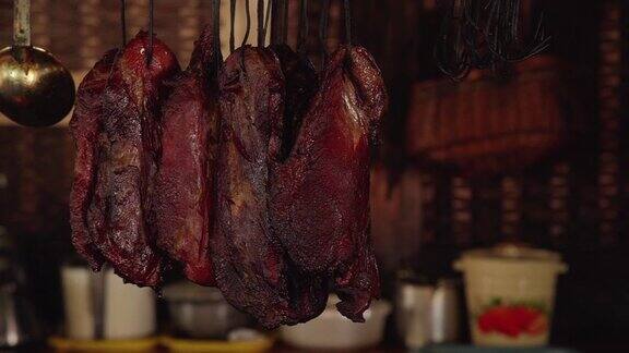 干猪肉和红肉品种挂在商店市场柜台的钩子上