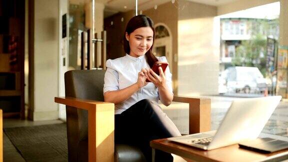 一个女人在咖啡馆用智能手机