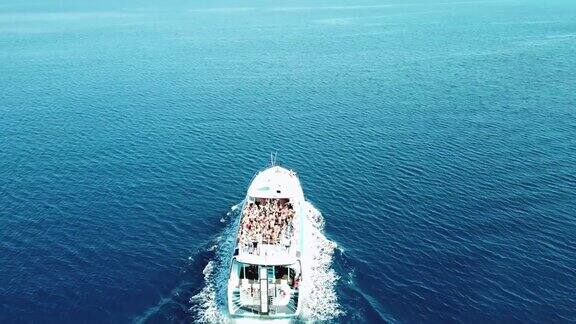 俯视图一艘快艇在清澈湛蓝的海面上航行人们在船上跳舞在白色的游艇上聚会