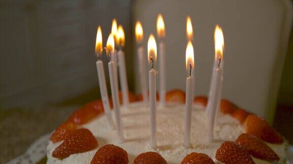 在美味的草莓椰子生日蛋糕上点燃蜡烛