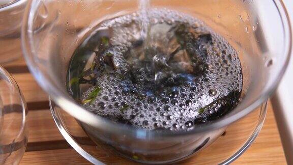 在杯子里泡茶把开水倒进玻璃杯盖过的过程