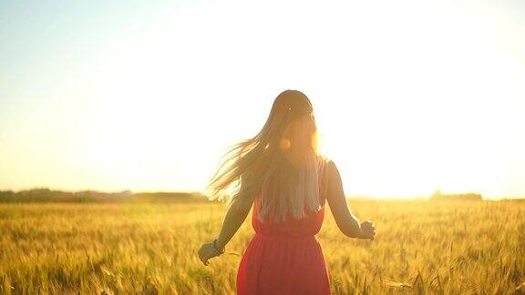 一个穿着红裙子的女孩在日落时分跑过田野慢动作