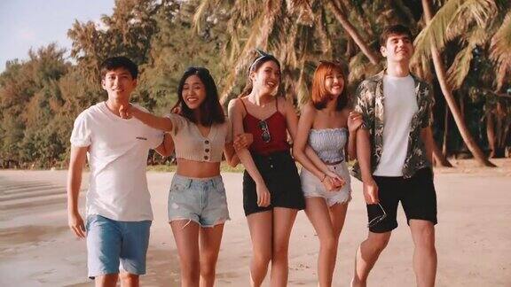 一群年轻的亚洲朋友喜欢在暑假的海滩上散步