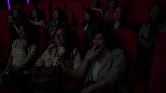 亚洲华人女性朋友在电影院笑着看电影