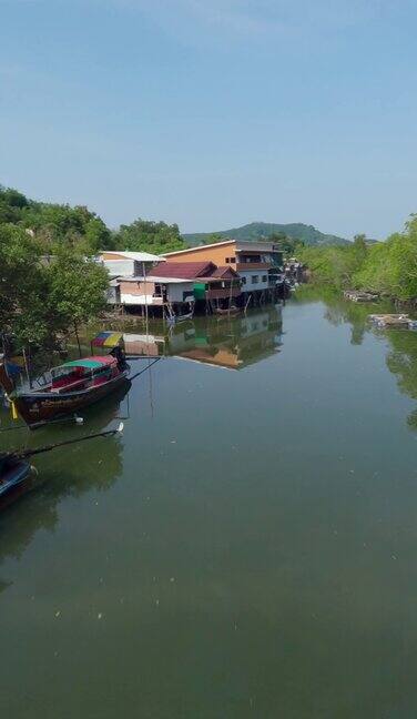 垂直视频4k传统的长尾渔船停泊在亚村水域