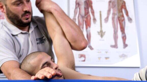在病人的手臂和背部工作的物理治疗师