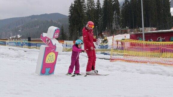 这孩子跟着教练学滑雪