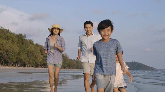 爸爸妈妈和孩子们白天在海滩上跑步缓慢的运动家庭假期和旅游