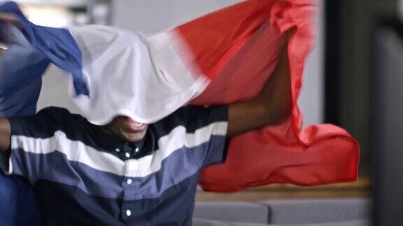 非洲人拿着法国国旗看电视比赛