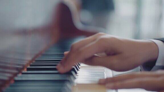男孩用手弹奏白色钢琴