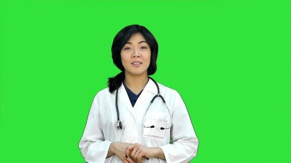 亚洲女医生展示一瓶药片在绿屏上展示药片