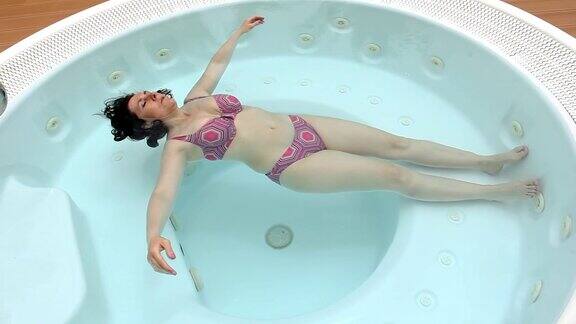 没有压力的女士躺在热水浴缸里