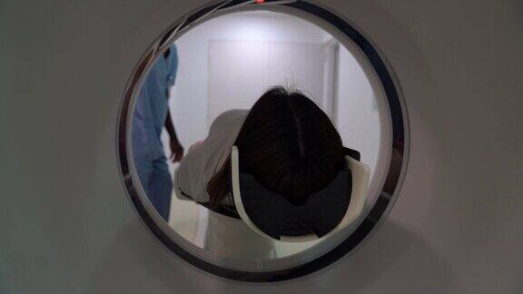 友善的放射科医生正在给一位女性病人做脑部扫描