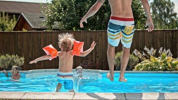 父亲和儿子跳进游泳池