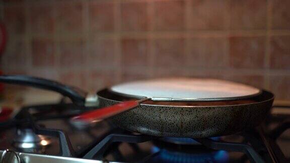 厨房炉子上的铸铁煎锅用橄榄油烤着肉片做汉堡肉饼用平底锅煎肉排