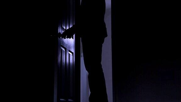 一个男人离开黑暗房间的剪影从左到右