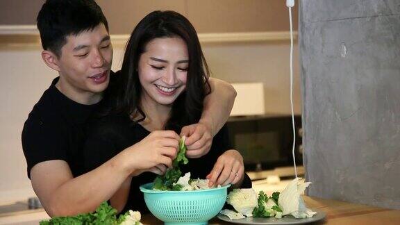 亚洲华人夫妇准备食物聊天微笑拥抱厨房在早上