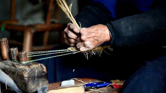 亚洲祖母在家里做传统的草鞋