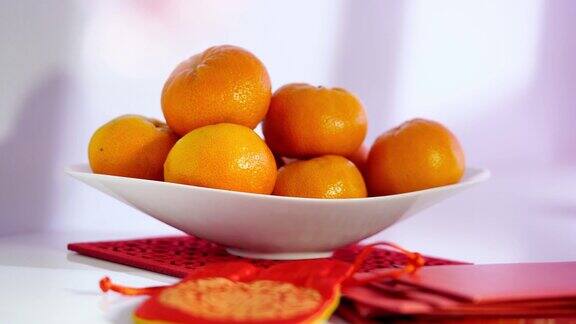 一碗橘子和红色幸运包作为中国新年的装饰元素