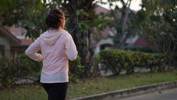 妇女早上在村公园跑步锻炼和健康