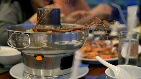 慢镜头泰国辣菜冬阴功在餐厅的桌子上人们在餐厅吃泰国菜