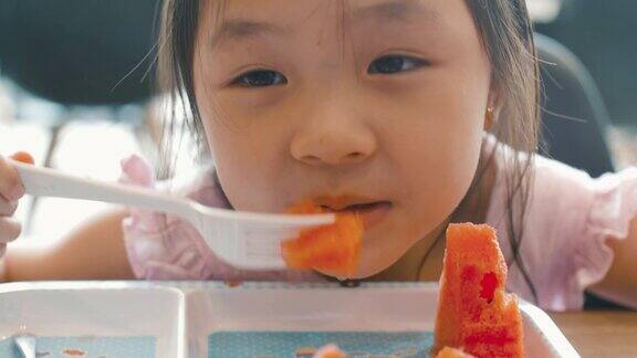 小女孩笑着吃西瓜