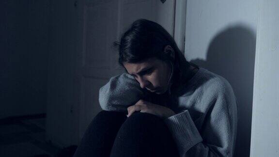沮丧的女人坐在走廊里在家里哭泣