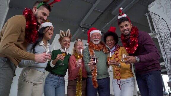 一群快乐迷人的多种族同事在办公室兴奋地庆祝圣诞节假期