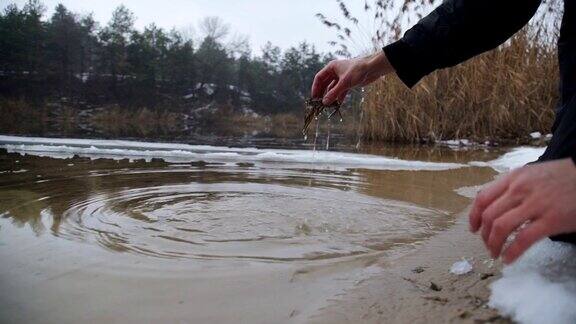 一个人从冰冷的河里捞出一只小龙虾