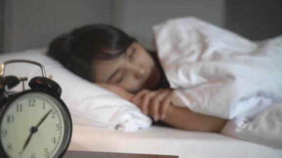 一个亚洲女人睡在卧室的床上