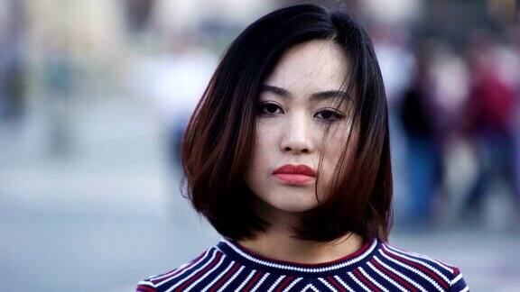 一位悲伤而严肃的中国妇女转过头看着镜头