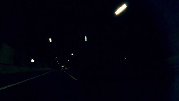 拍摄于城市公路隧道黄昏时分在城市高速公路上行驶穿过城市的车流