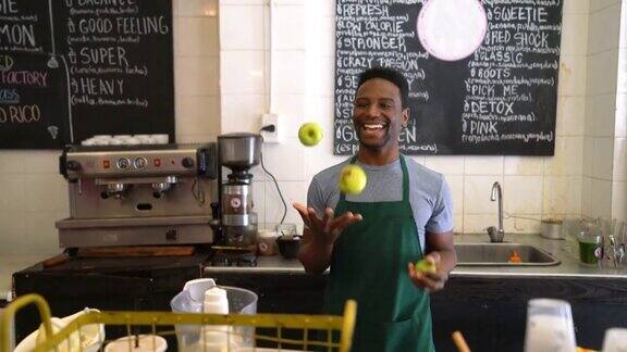 快乐的黑人工人在榨汁机和水果玩得很开心对着镜头微笑