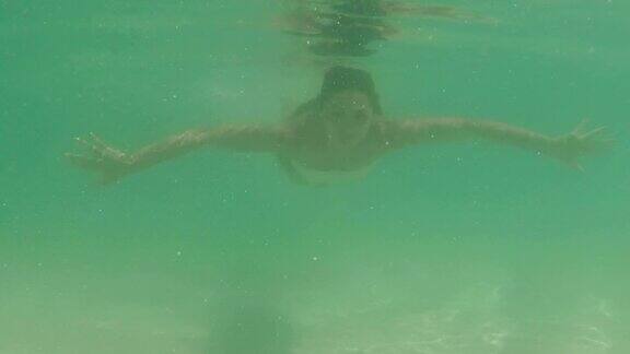 水下的女人游泳在海里水下行动相机POV年轻女孩在海滩上比基尼