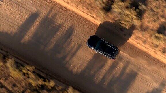 空中特写:飞色越野车行驶在沙漠道路上