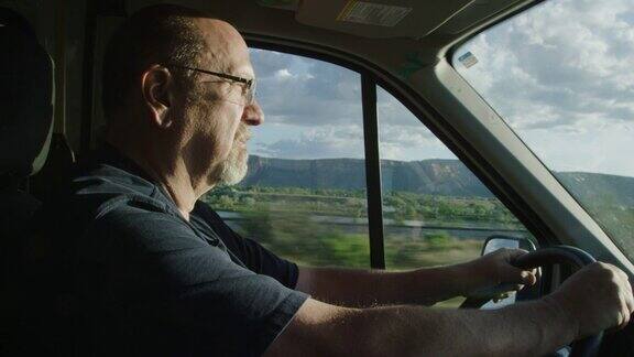 一个阳光明媚的日子里一名五十多岁的白人男子在科罗拉多西部的黎明日落开着一辆卡车