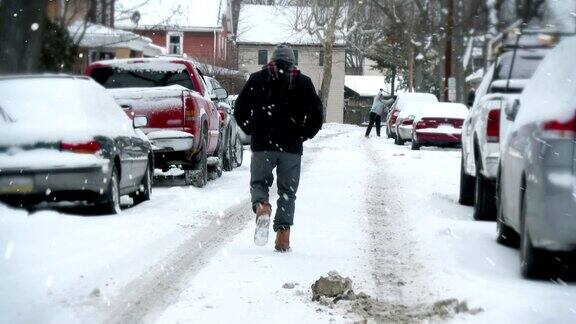 男人走在下雪的街上