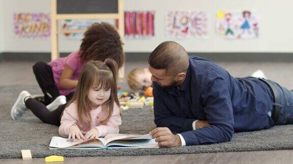 男幼儿园老师给学生读书