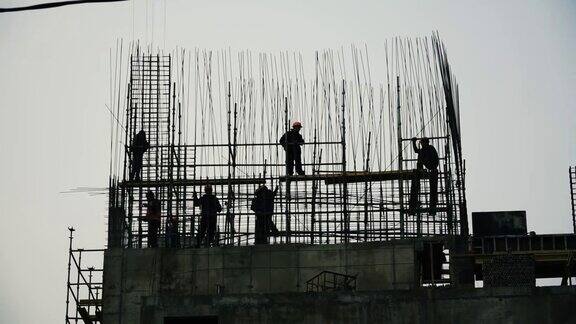 建筑工地上的工人剪影夹建筑工地一个戴着头盔的工人的剪影