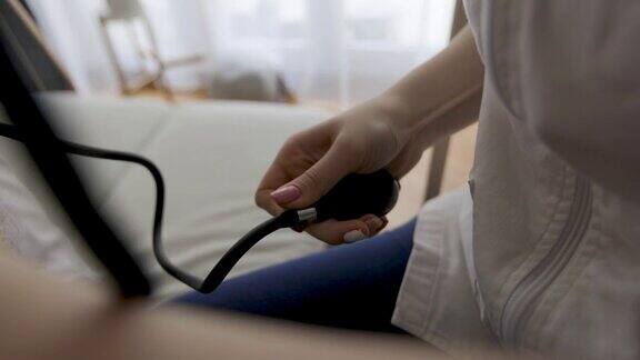 女护士在家为老年病人测血压