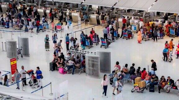 4K时间的流逝拥挤的旅客在机场航站楼的值机柜台等待行李