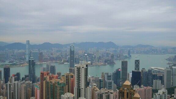 4k俯瞰香港城市景观俯瞰太平山顶展现繁忙的维多利亚港和中国香港中环金融区香港岛的和一对鹰在城市上空飞翔