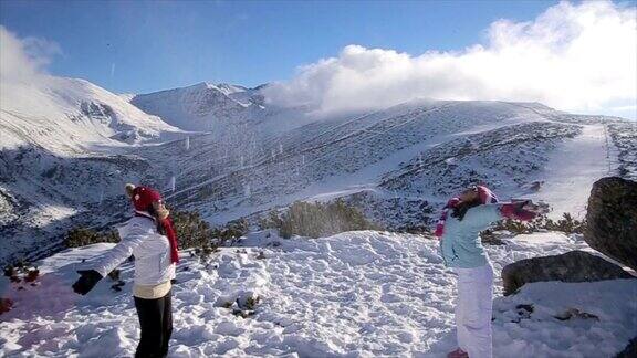 妈妈和女儿在神奇的山顶上玩雪