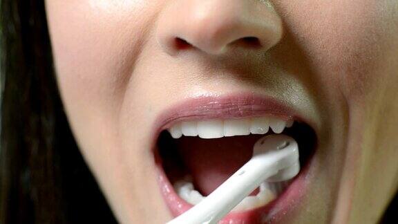 女人用电动牙刷刷牙的特写
