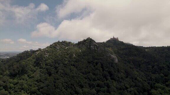 空中上升镜头捕捉到美丽的云景和远处山上的Pena宫殿