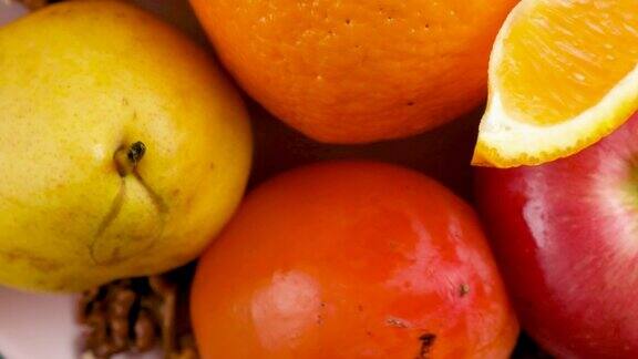 苹果柿子梨和橙子旋转特写
