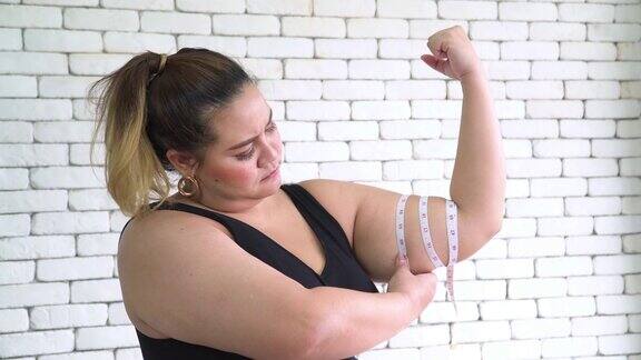 泰国超重妇女用卷尺测量她的手臂