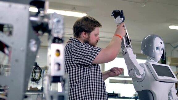 工程师抬起机器人的手臂在它们的槽中添加螺丝螺母4k