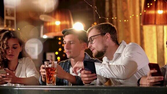 朋友男人女人休闲友谊和科技概念-朋友与智能手机在酒吧或酒吧喝啤酒