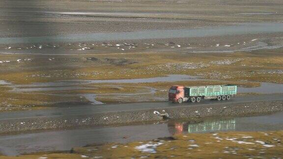 一辆卡车在西藏空旷的公路上飞驰